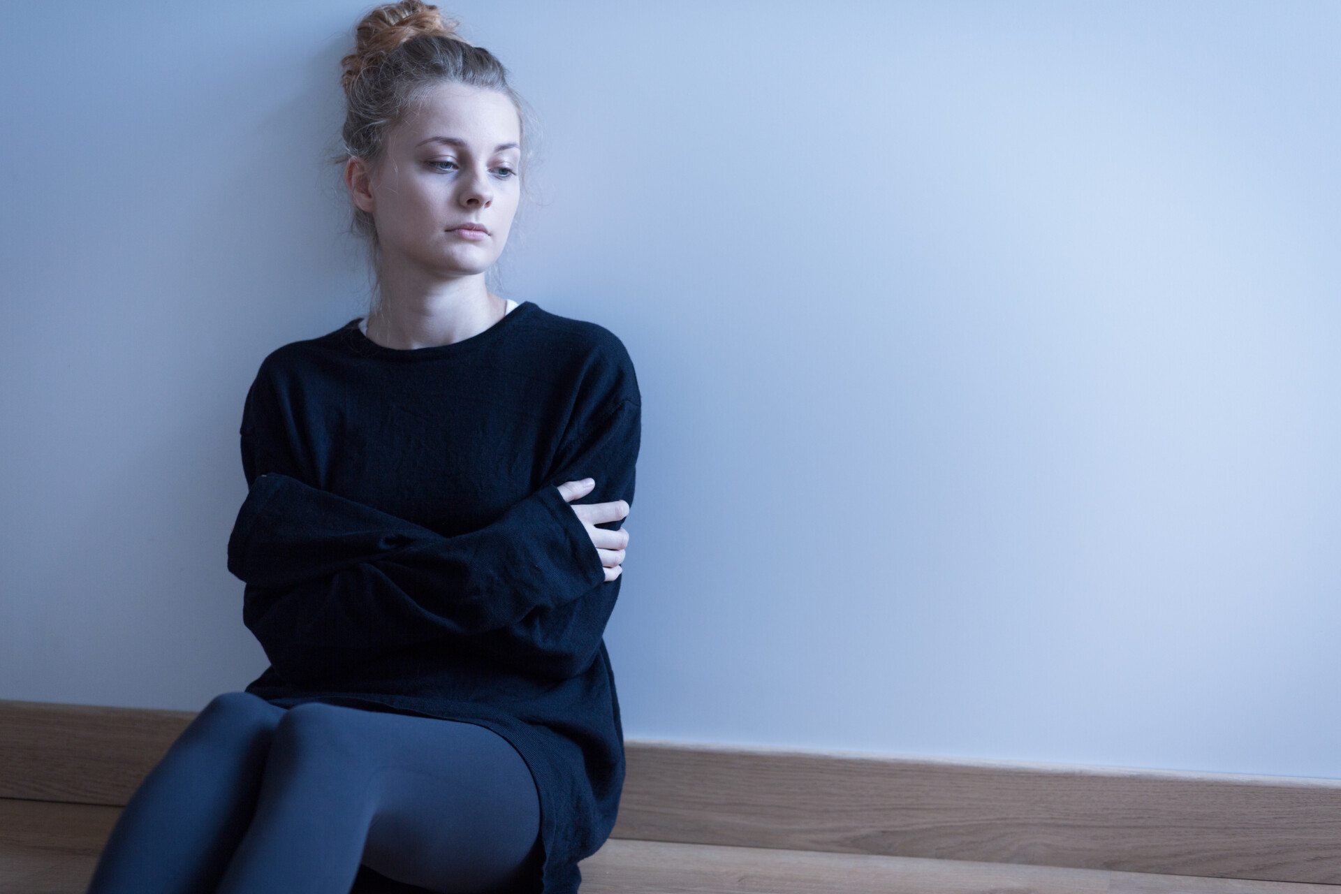 Young woman with anxiety disorder sitting on the floor. avpd vs social anxiety