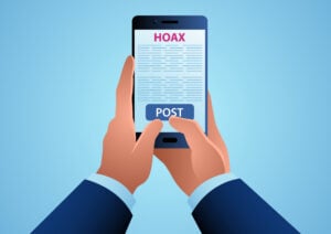 a man holding a smartphone about to post a written hoax